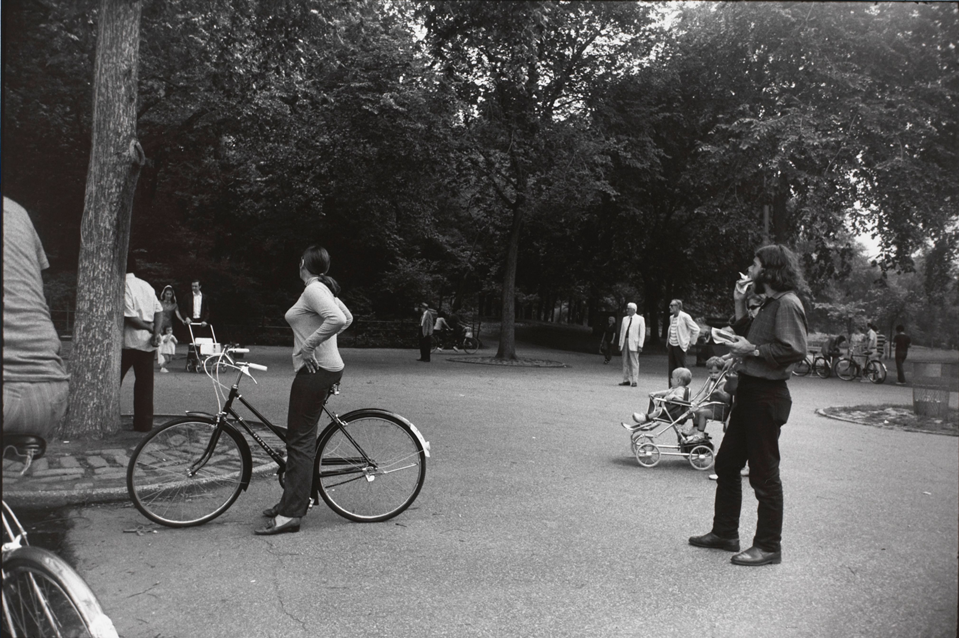 Untitled (Woman on a bicycle in park, looking away from the camera)
