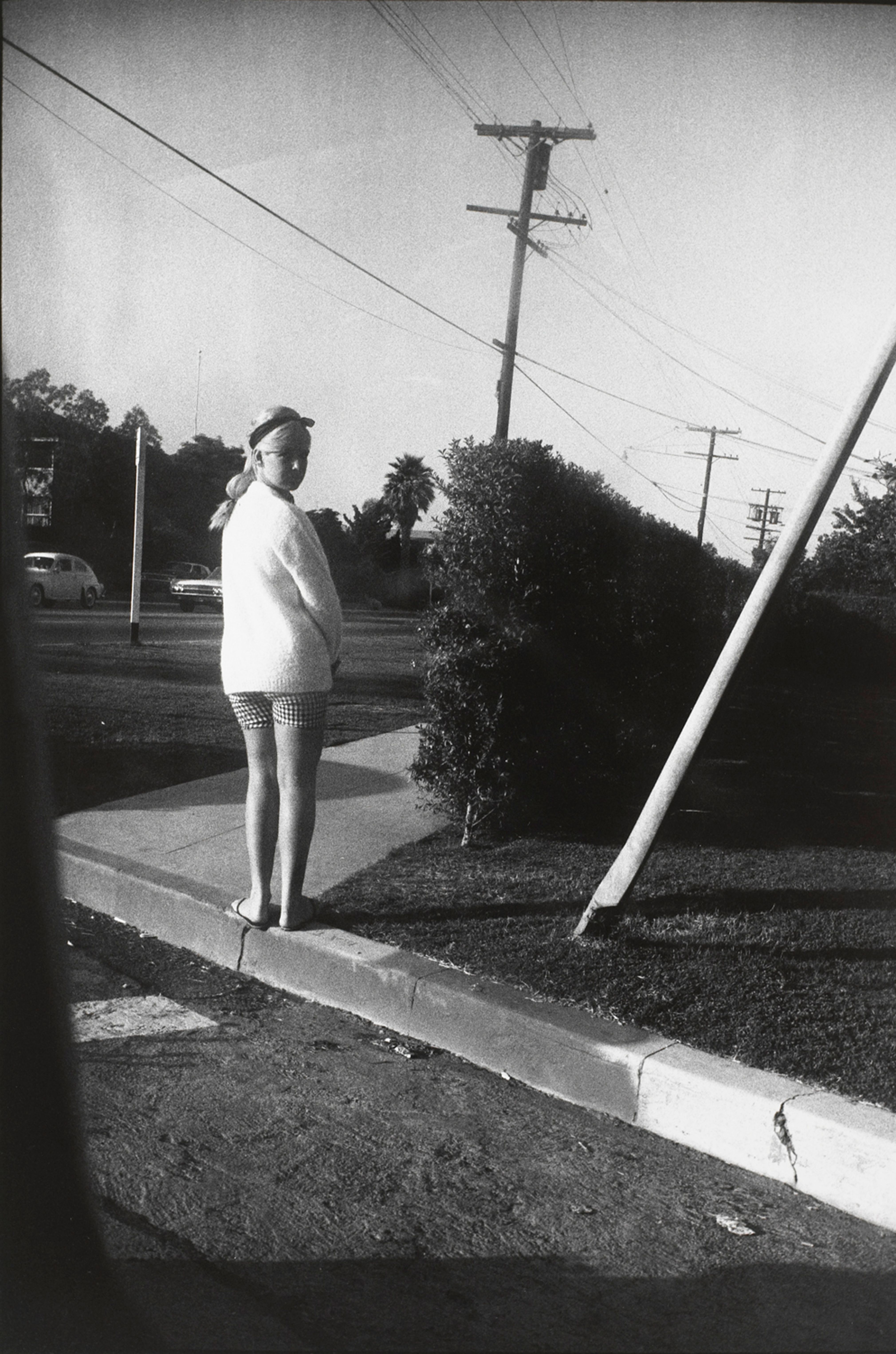 Untitled (Woman in white sweater and checkered shorts with back to camera)