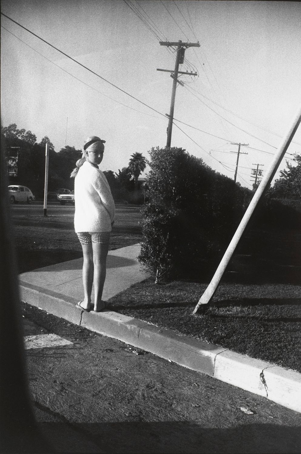 Untitled (Woman in white sweater and checkered shorts with back to camera)