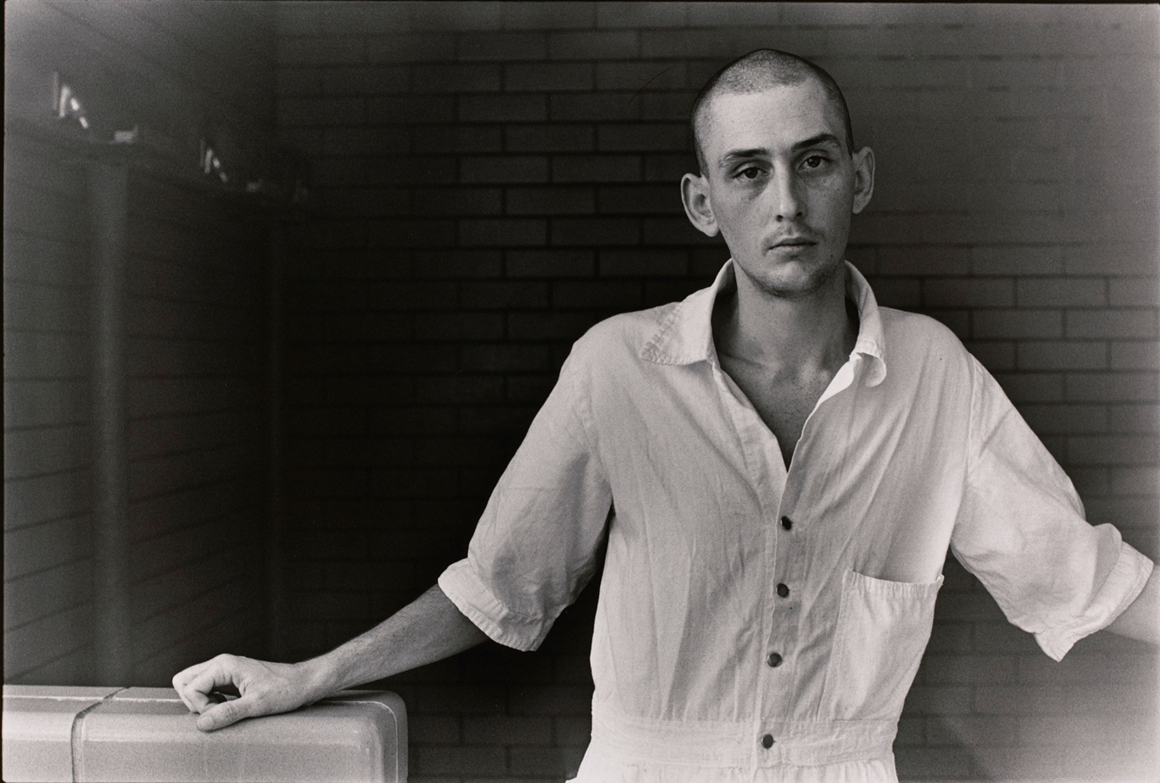 Untitled (Inmate with shaved head in white uniform)