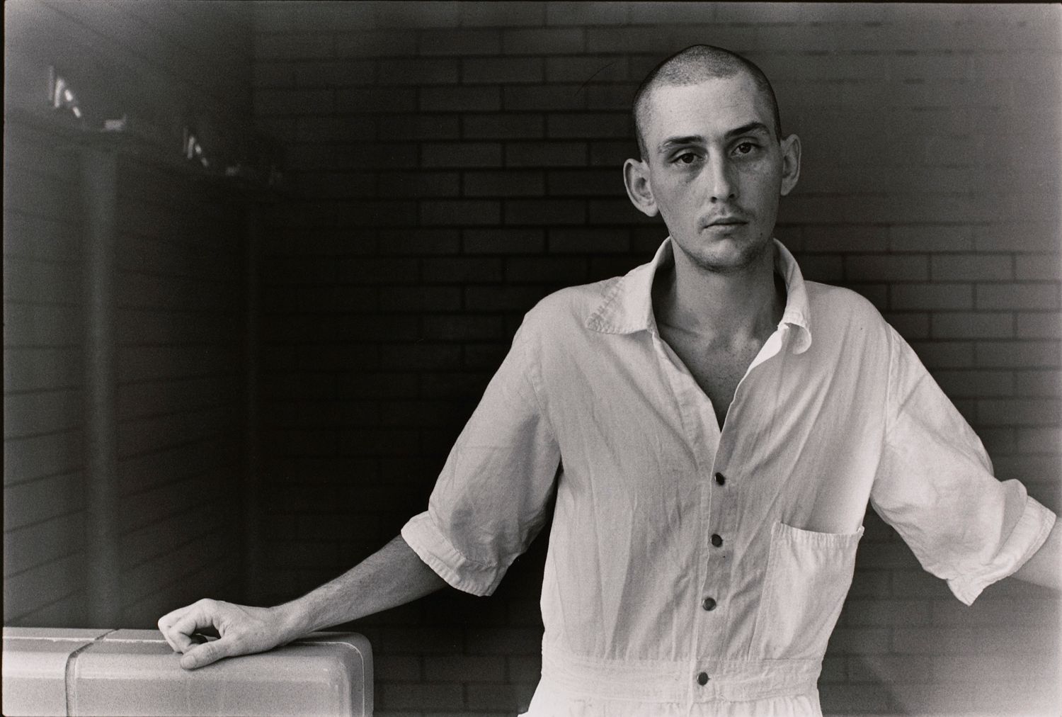 Untitled (Inmate with shaved head in white uniform)