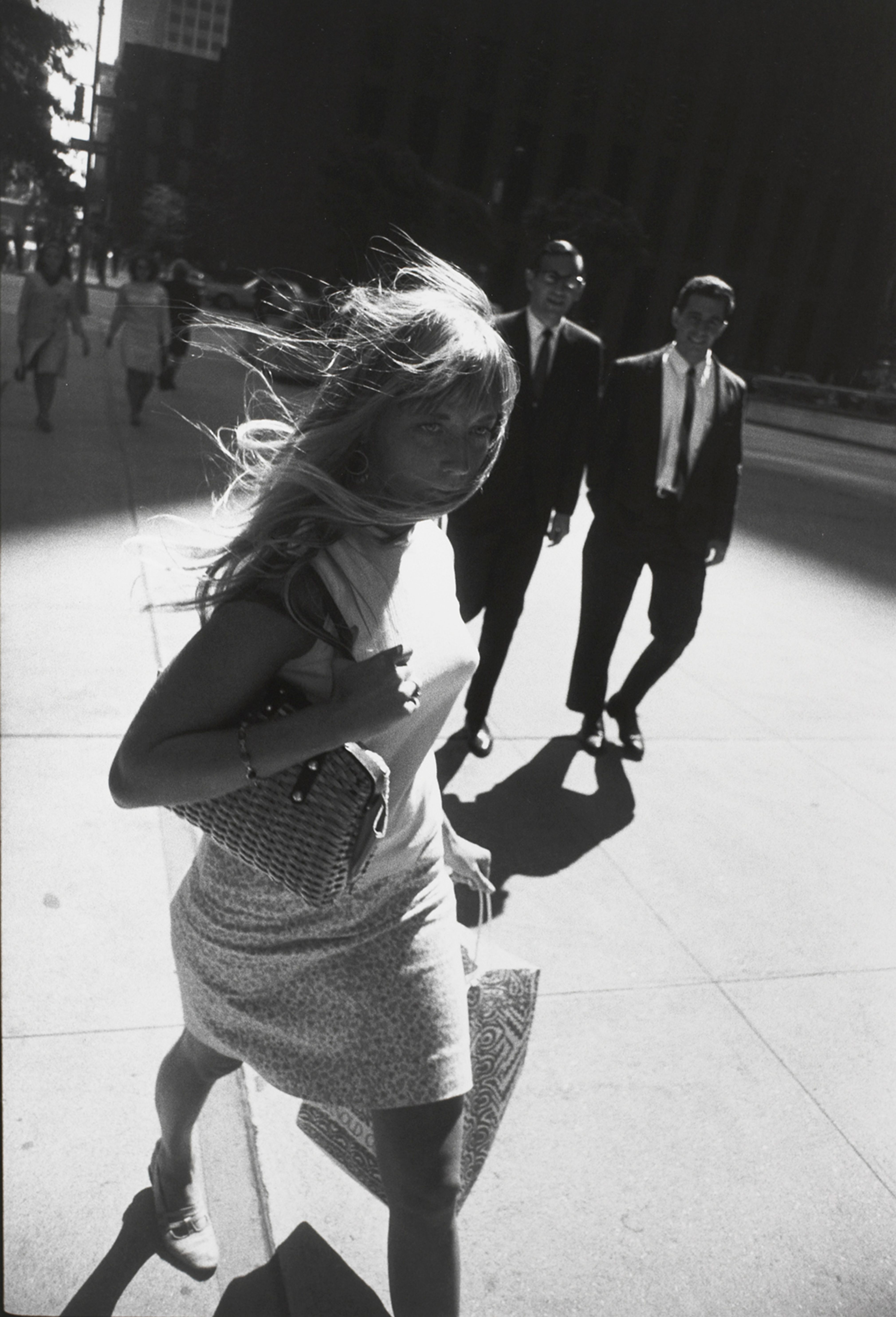 Untitled (Woman walking down street with her hair blowing behind her)