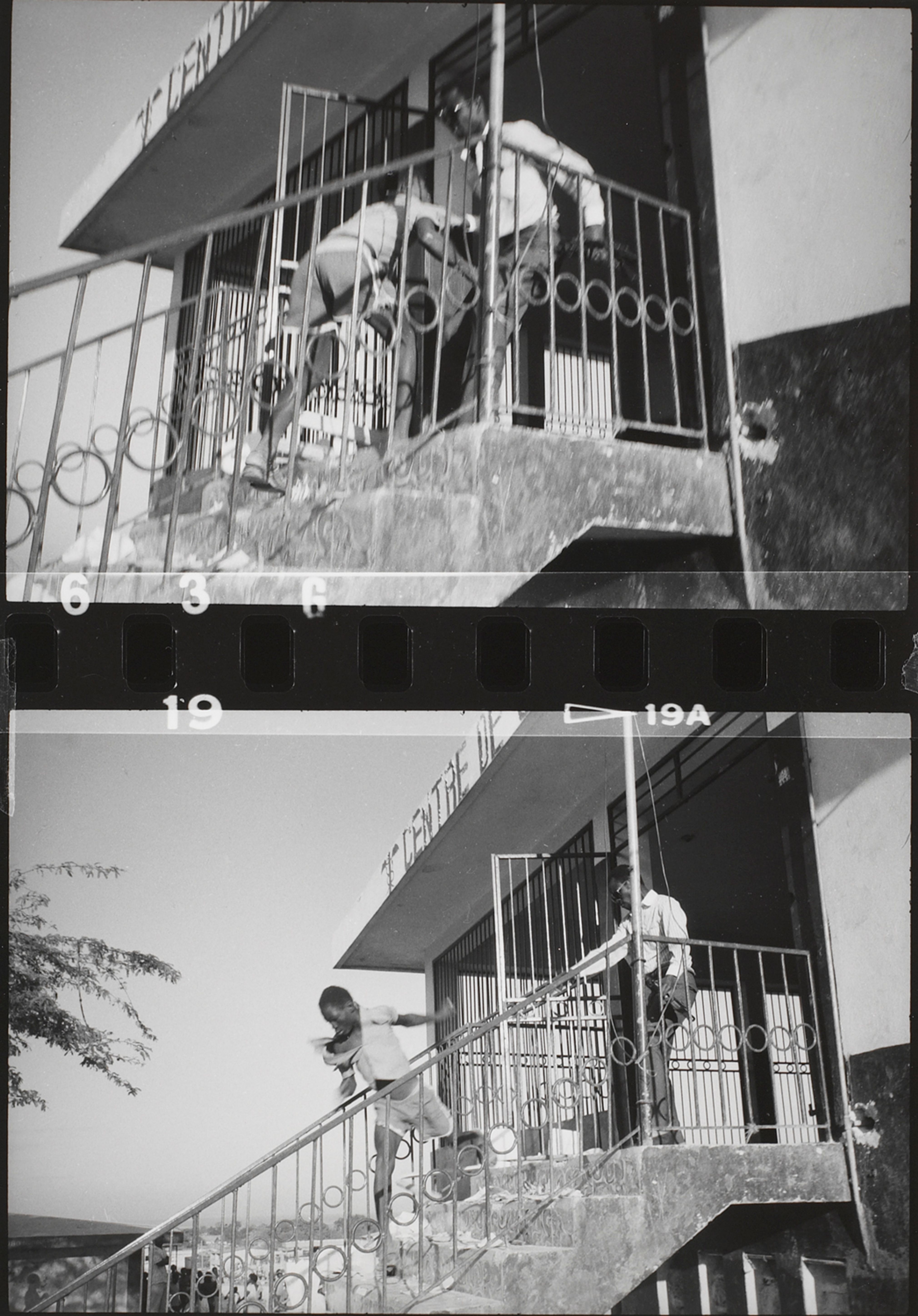 An out-of-uniform Tonton Macoute throws looter down a flight of stairs