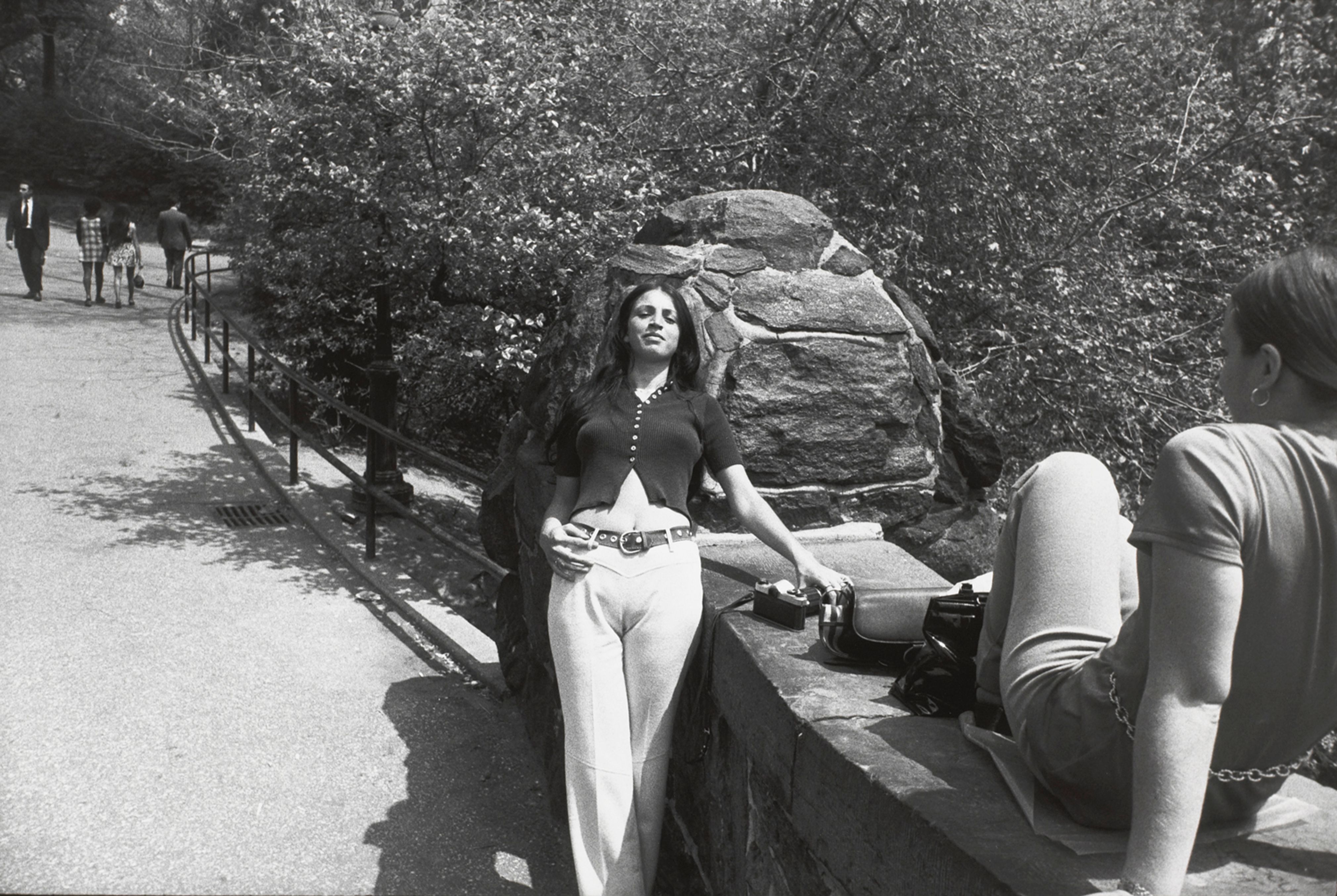 Untitled (Woman leaning against a rock with another facing her on seated on bridge overpass)
