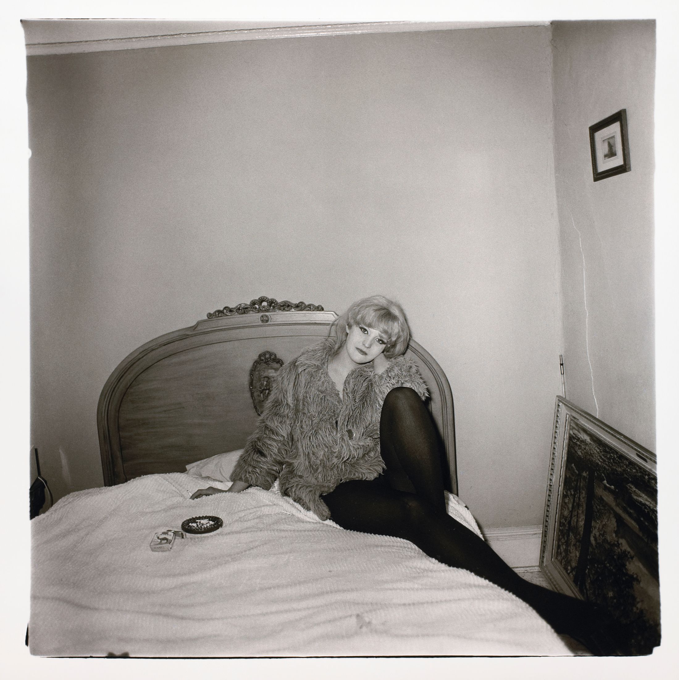 Girl in a coat lying on her bed, N.Y.C.