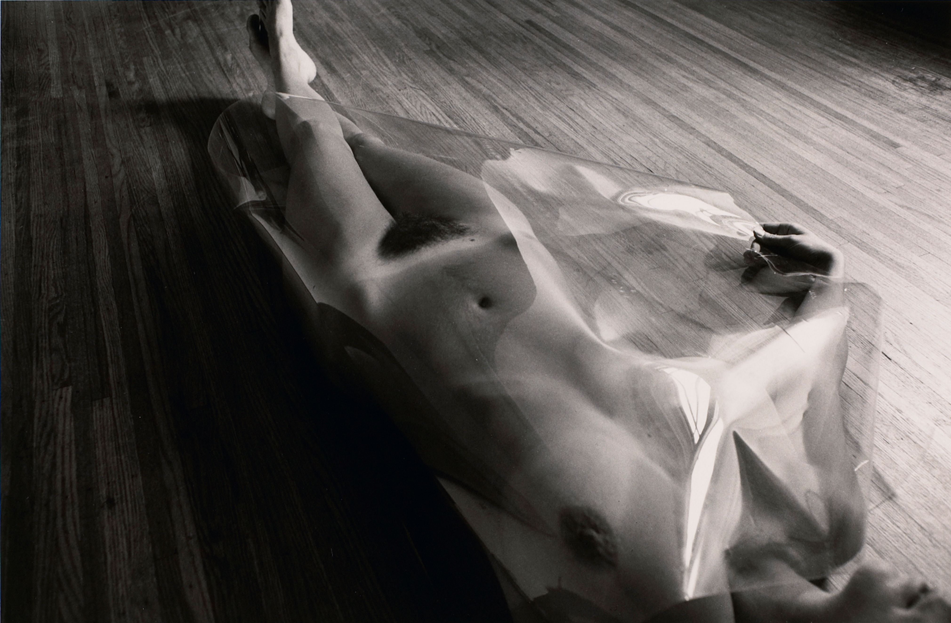 Untitled: Woman Laying On Wood Floor with Plastic Covering