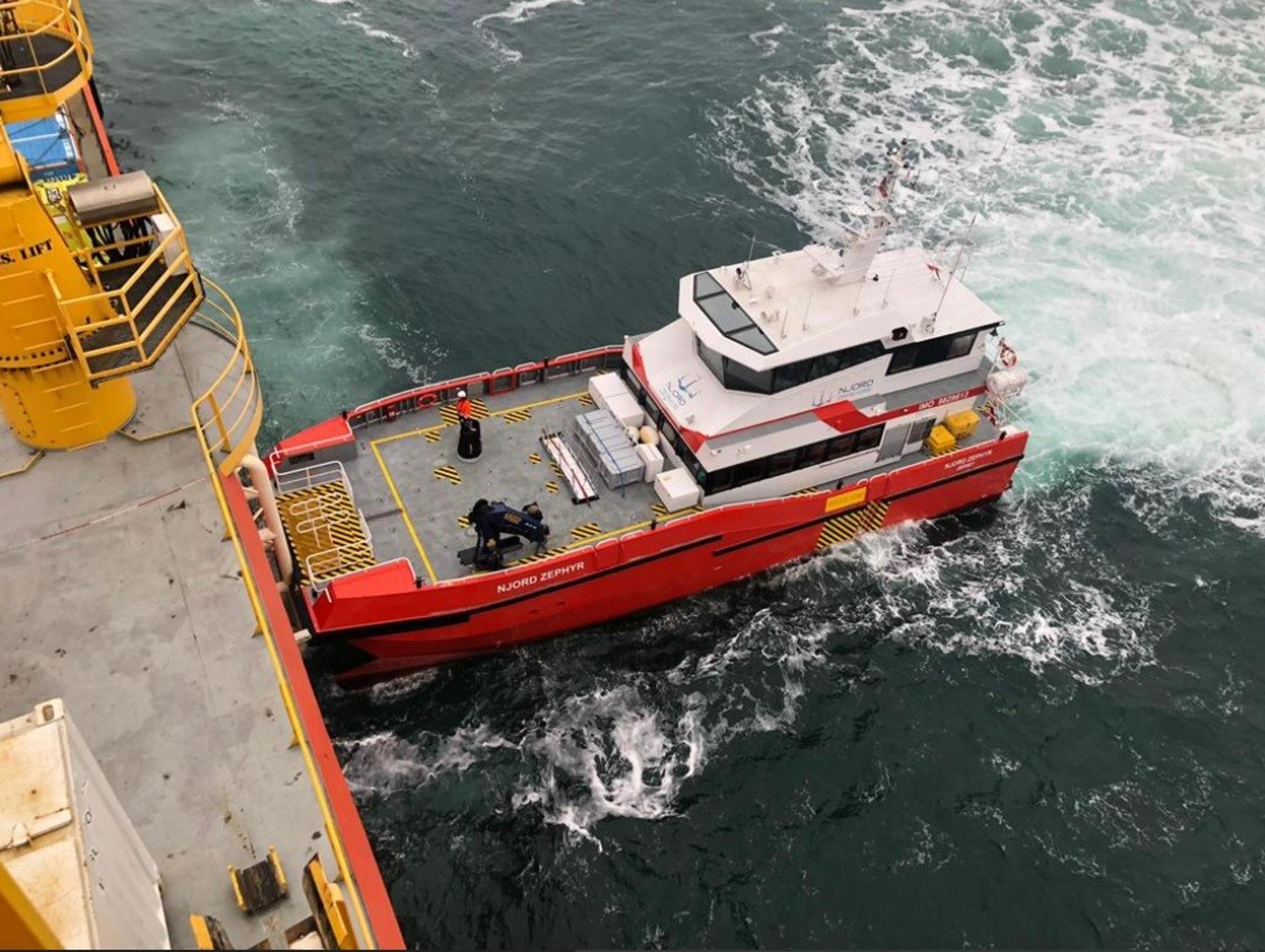 Crew transfer vessel pushing on against an offshore wind turbine boat landing