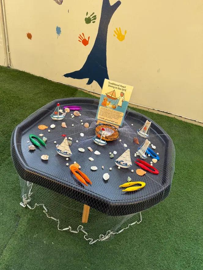 Pearl-diving discovery tray with toy boats and shells