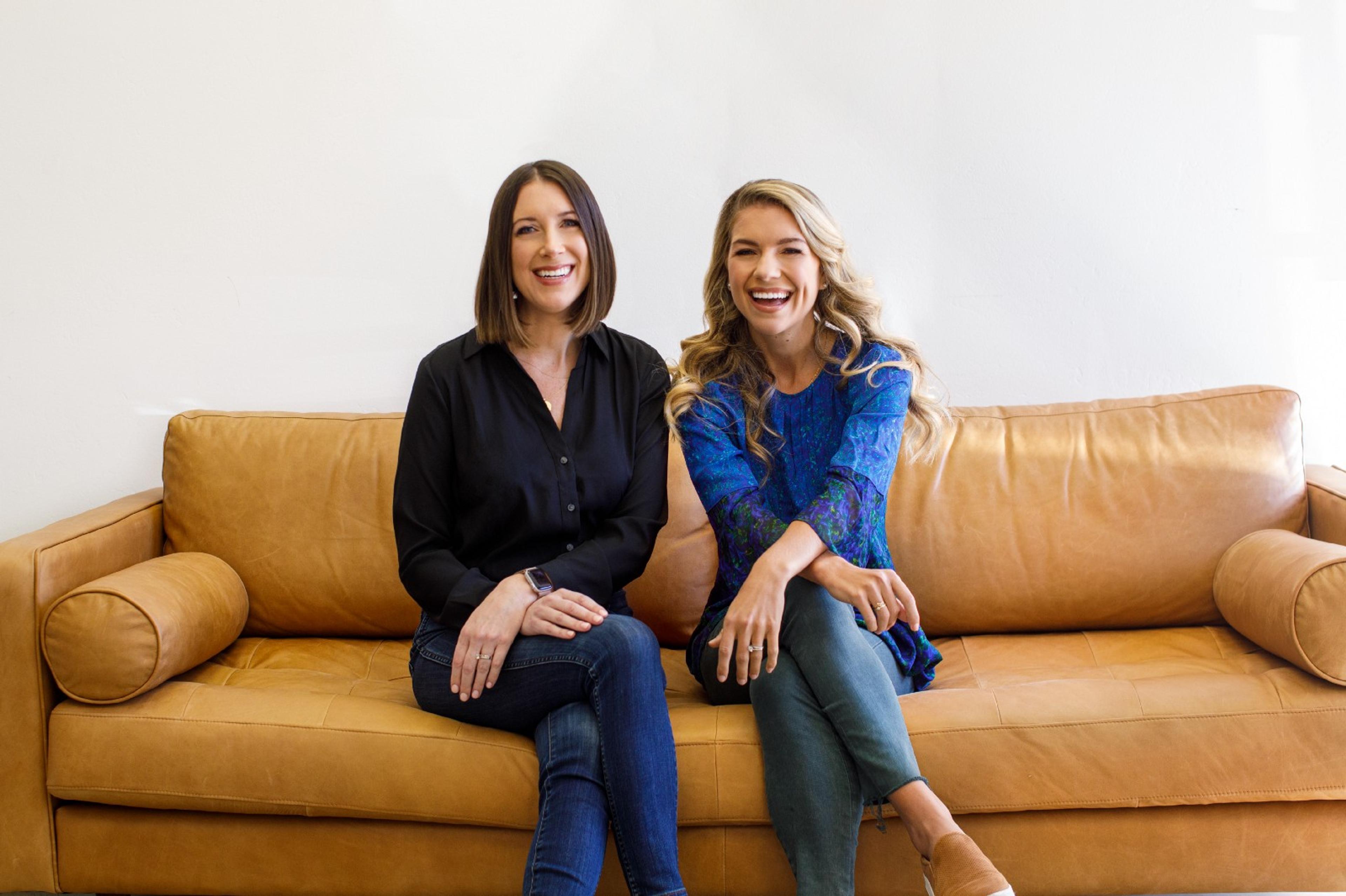 Equip founders Erin Parks and Kristina Saffran sit smiling on a beige couch