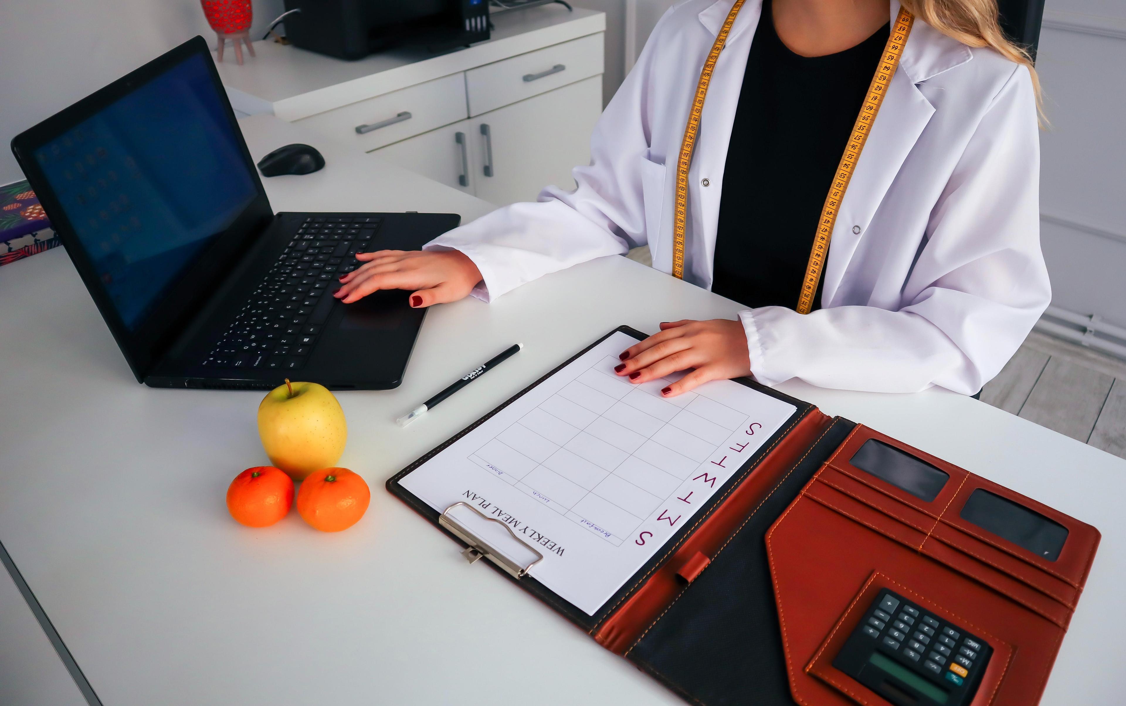 Dietitian at their desk with a meal planning calendar