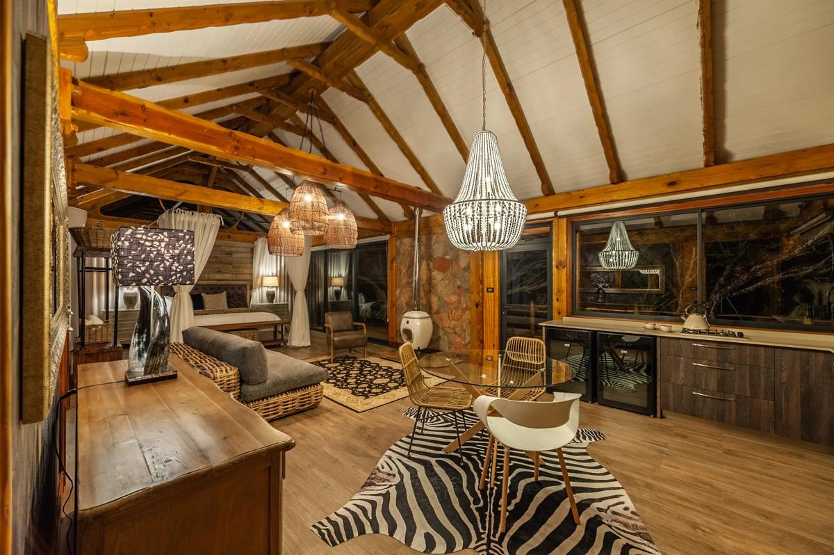 A room in Mont Eco Private Reserve displaying animal skins on the floor and an ornate chandelier