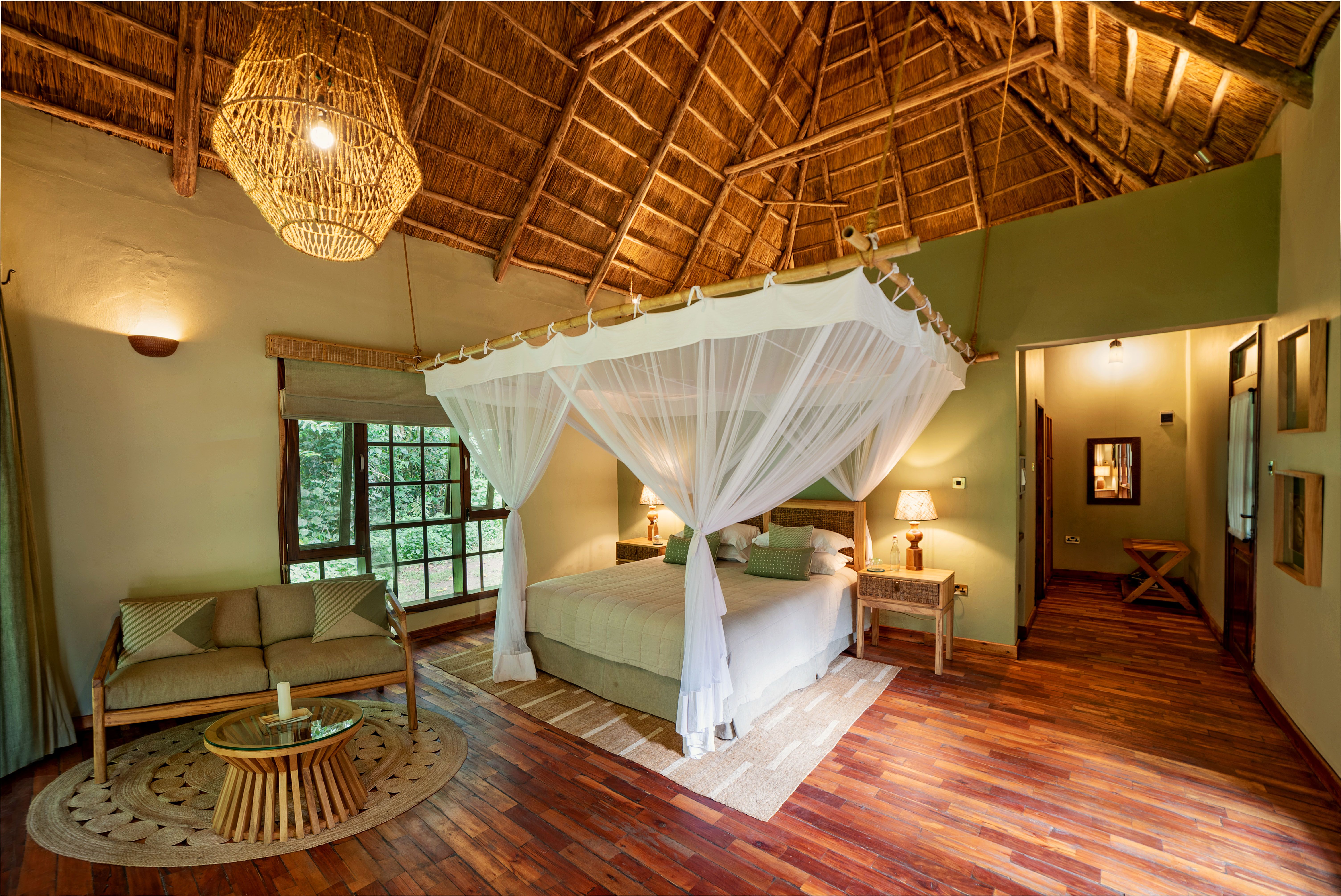 Double four poster bed with mosquito net in double volume chalet