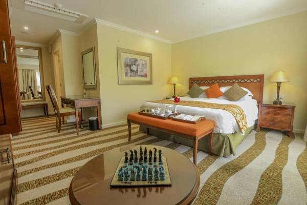 Executive suite bedroom with double bed and table with chess board
