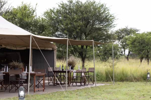 Luxury tent patio with dining tables and chairs under awnings