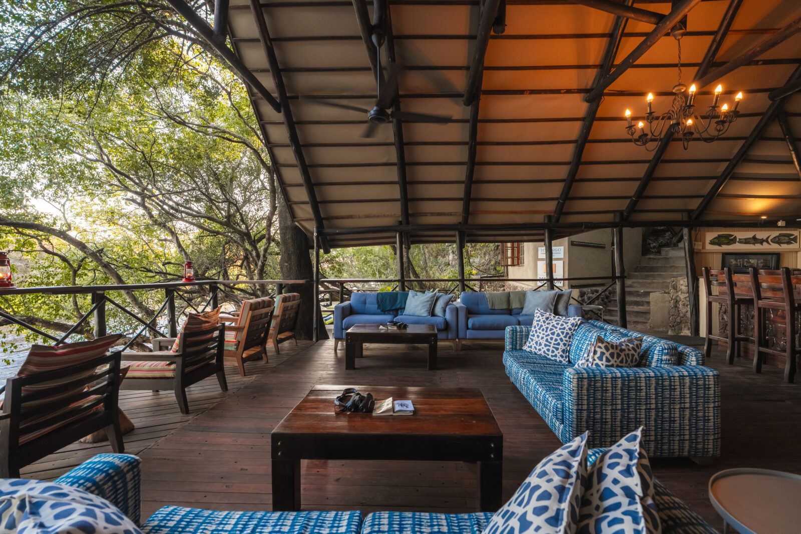 Ichingo Chobe River Lodge outdoor lounge with blue sofas and wooden coffee tables