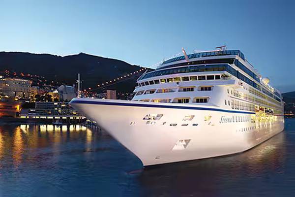 Ship Exterior – Sirena docked at port, illuminated at dusk