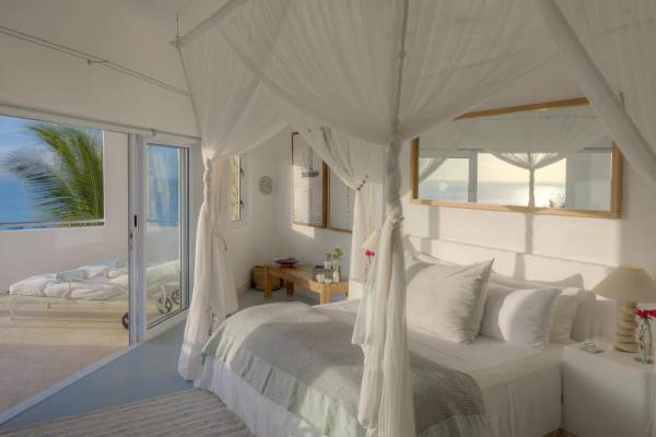 Hotel suite with seaview veranda and four poster double bed with mosquito net