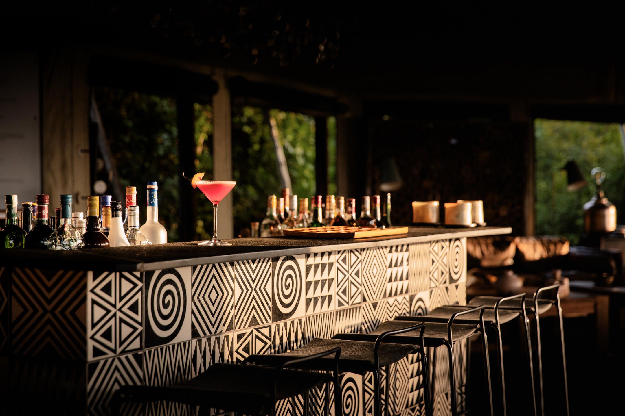 Bar with bar stools and pink martini glass drink on the counter