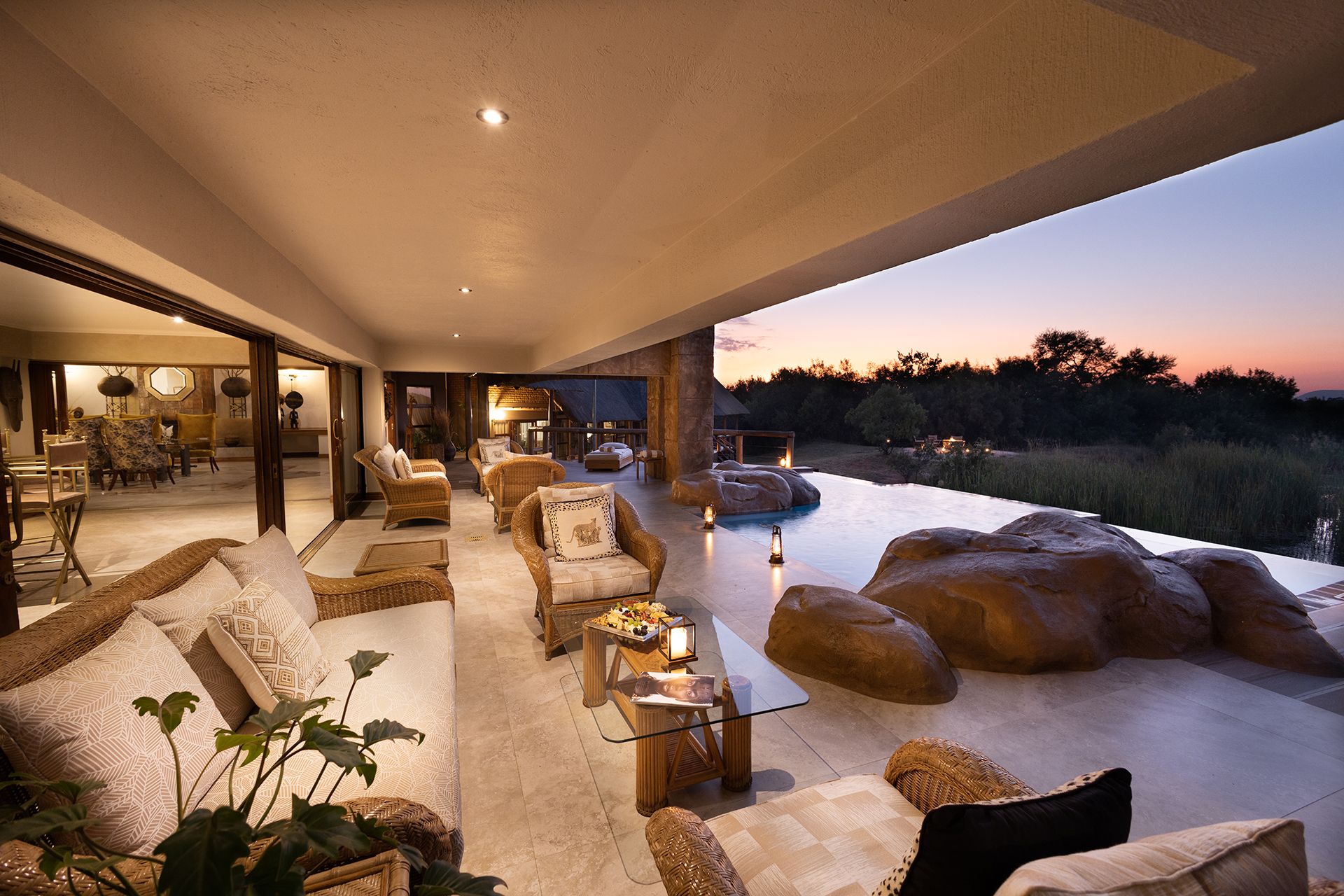 Kingfisher Villa lounge area illuminated at night with rock features overlooking grassland