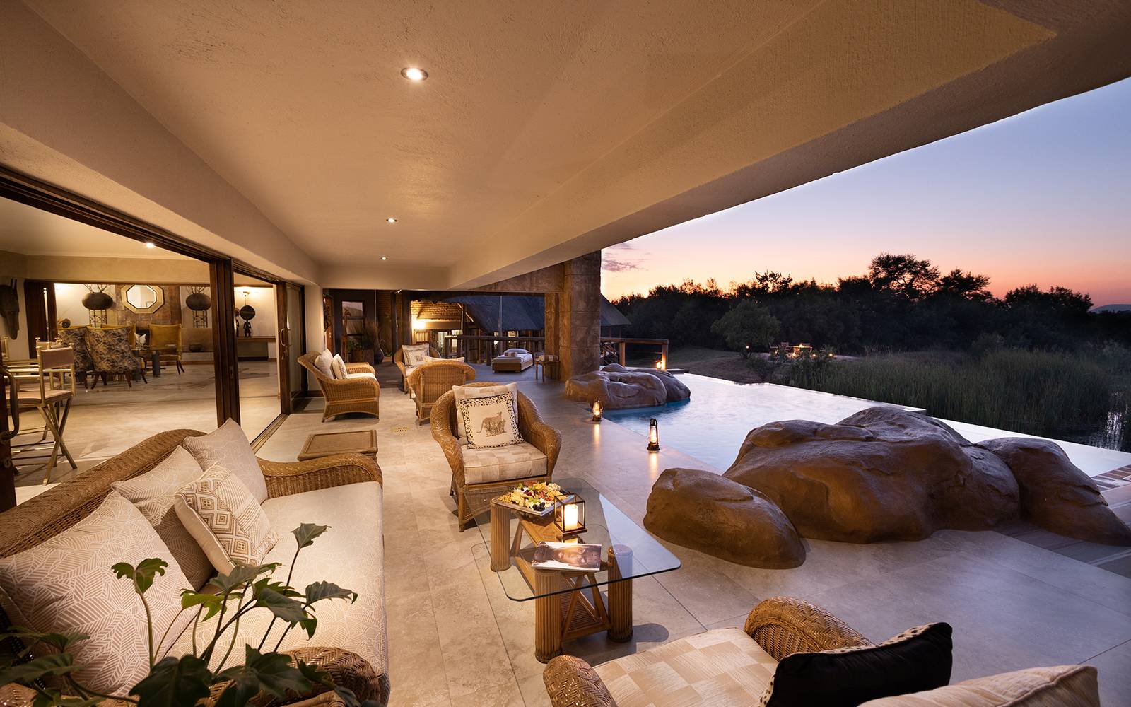 Kingfisher Villa lounge area illuminated at night with rock features overlooking grassland
