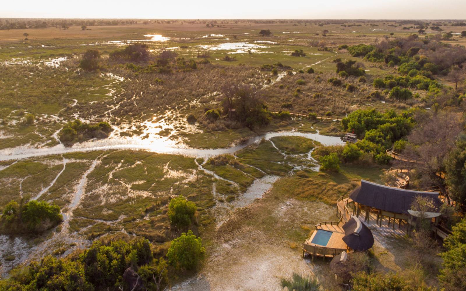 Aerial view of Okavango Delta and chalets and pool of Camp Okavango