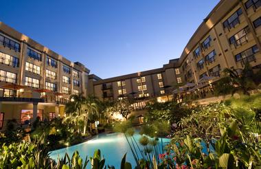Large hotel courtyard with pool illuminated at night