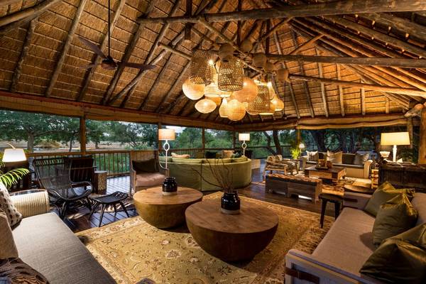 Sabi Sabi lounge beneath thatched roof with lush sofas and wooden tables
