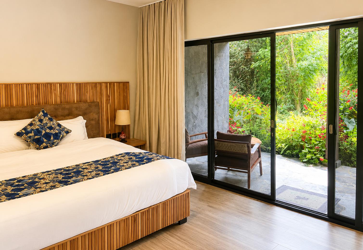 King size bed in room with veranda overlooking green garden