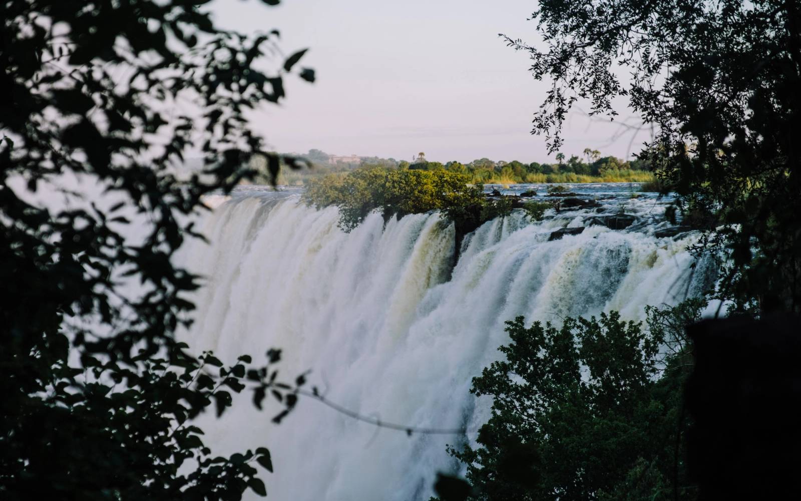 Victoria Falls waterfall framed by leaves