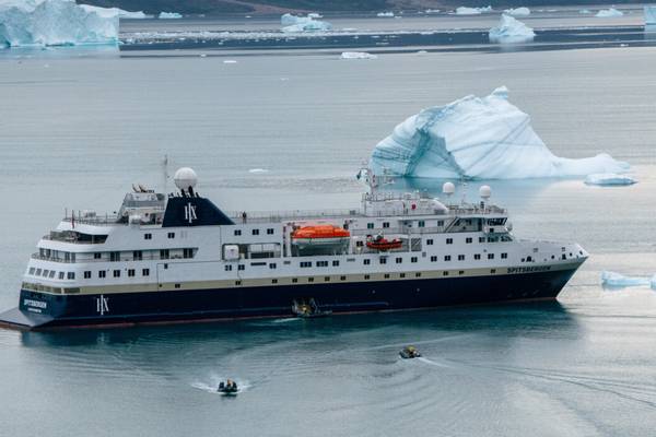 Spitsbergen cruise ship on an icy ocean with ice bergs floating in the distance.