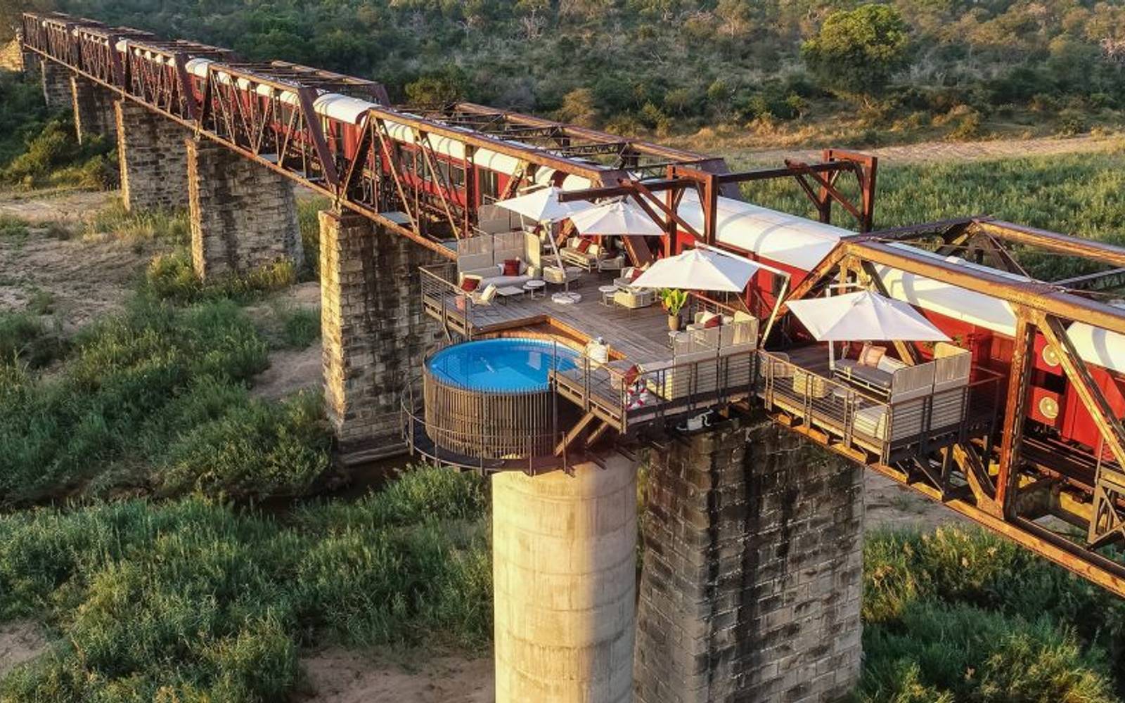 Kruger Shalati Bridge with stationary red and white train and balcony with round pool