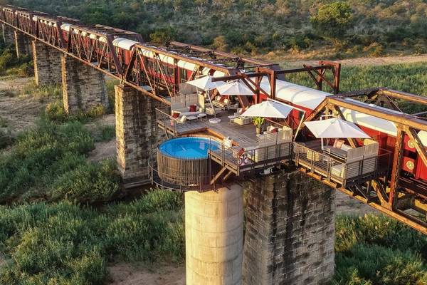 Kruger Shalati Bridge with stationary red and white train and balcony with round pool