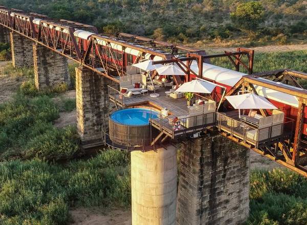 Kruger Shalati Bridge with stationary red and white train and balcony with round pool