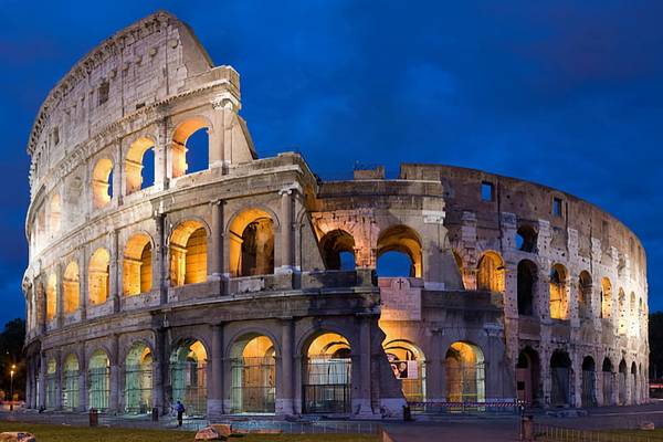The Colosseum in Rome at night with beautiful lights coming from the colosseum