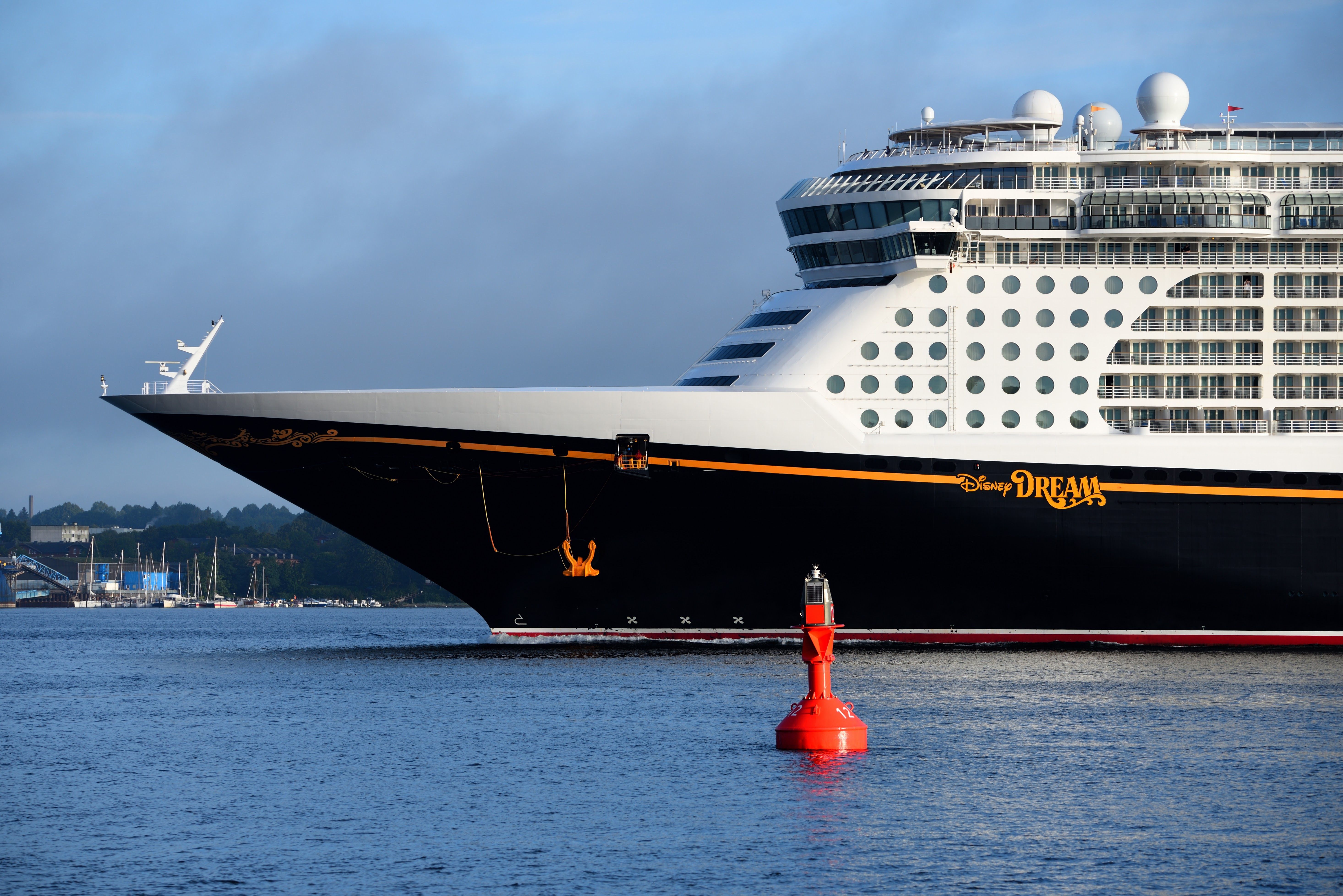 A Disney Dream cruise ship with a black body, yellow "Disney Dream" in writing and white upper deck with many round windows.