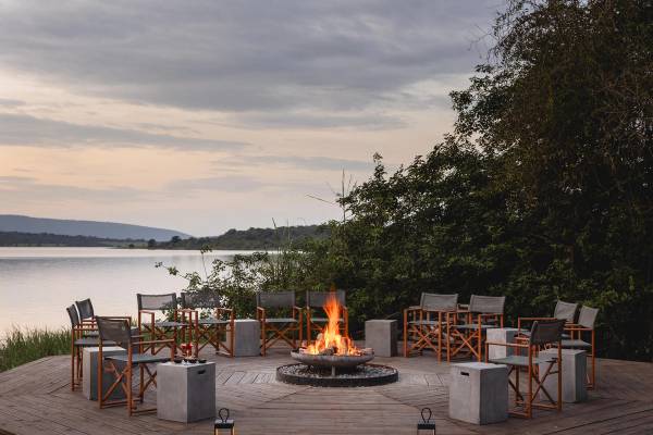 Fireplace with wood and canvas deck chairs surrounding in a circle