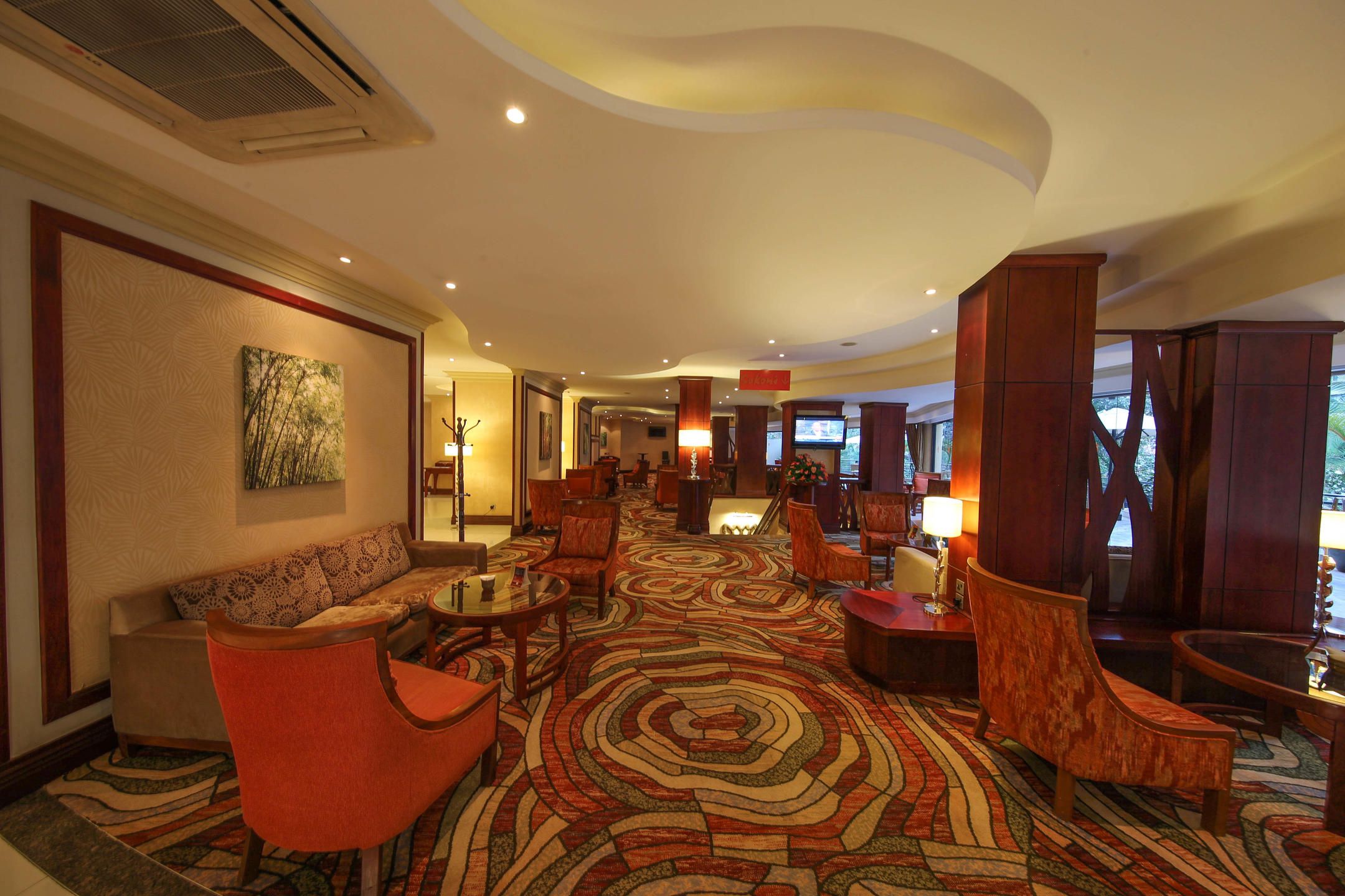 Vibrant carpeted guest lounge with red armchairs