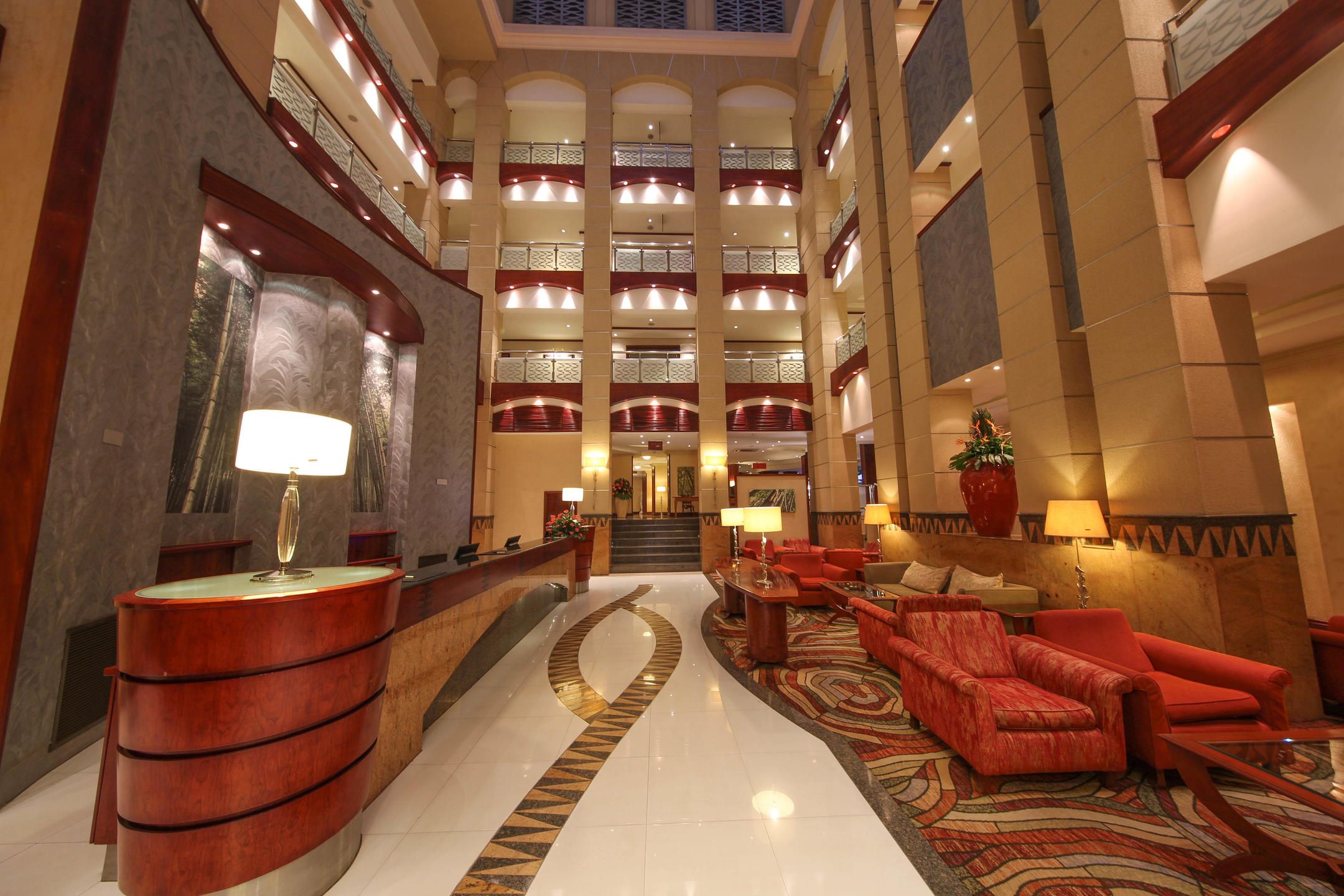 Reception area of three story Kigali Serena Hotel with red furnishings