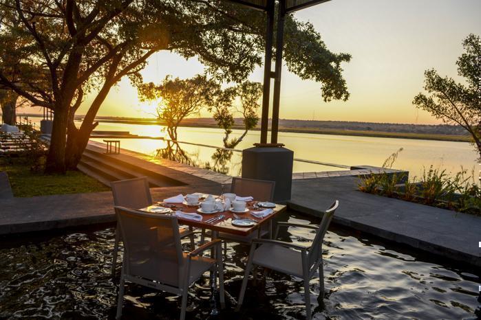 Chobe Water Villas dinner table over water at sunset