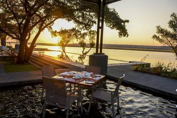 Chobe Water Villas dinner table over water at sunset