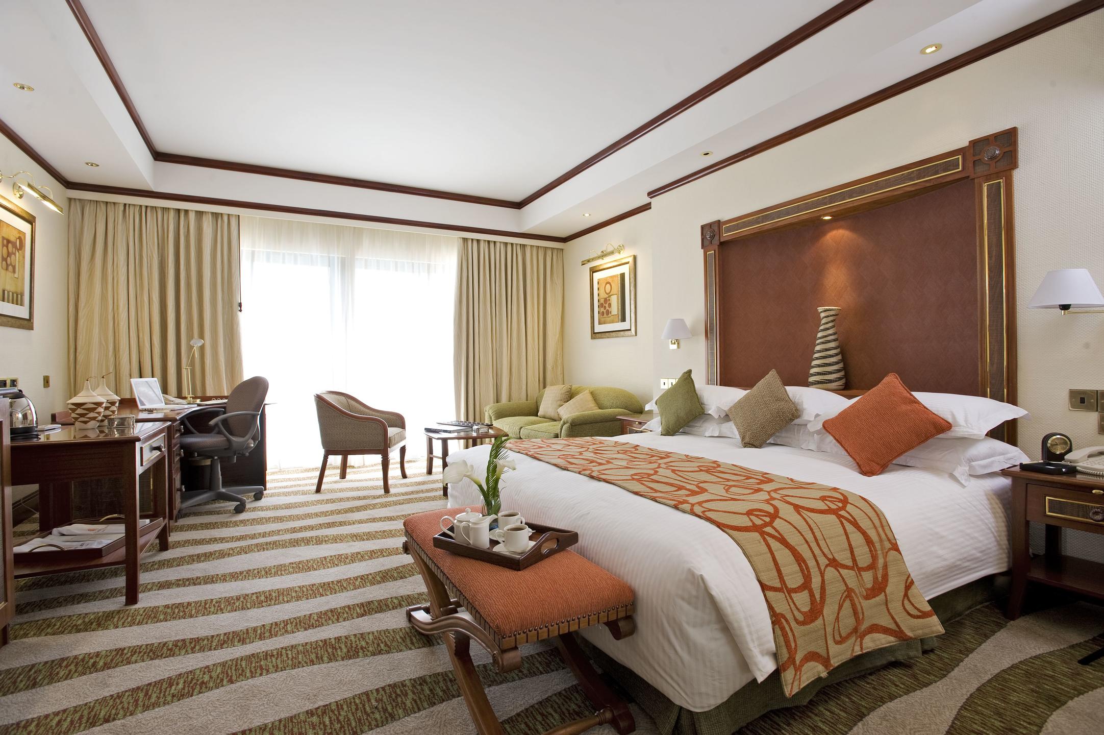 Large hotel suite bedroom with double bed and lounging area