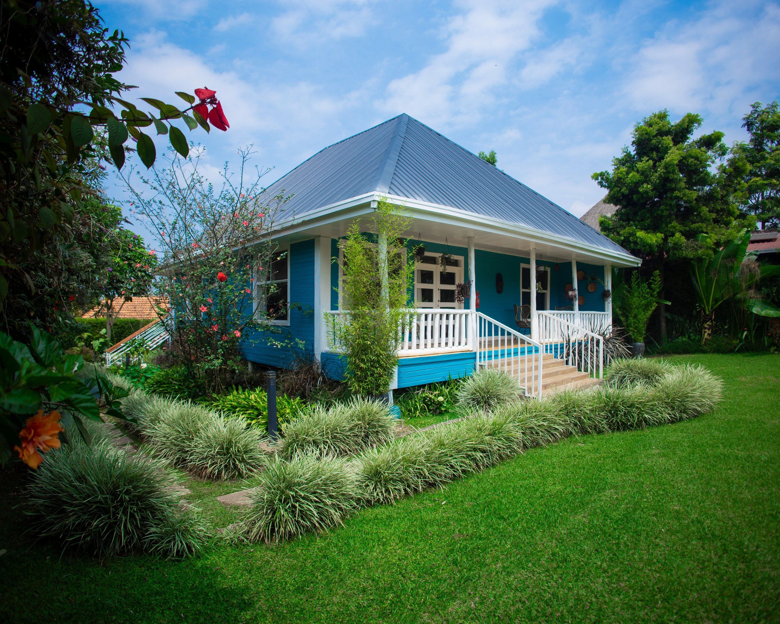 Blue wooden house surrounded by green garden