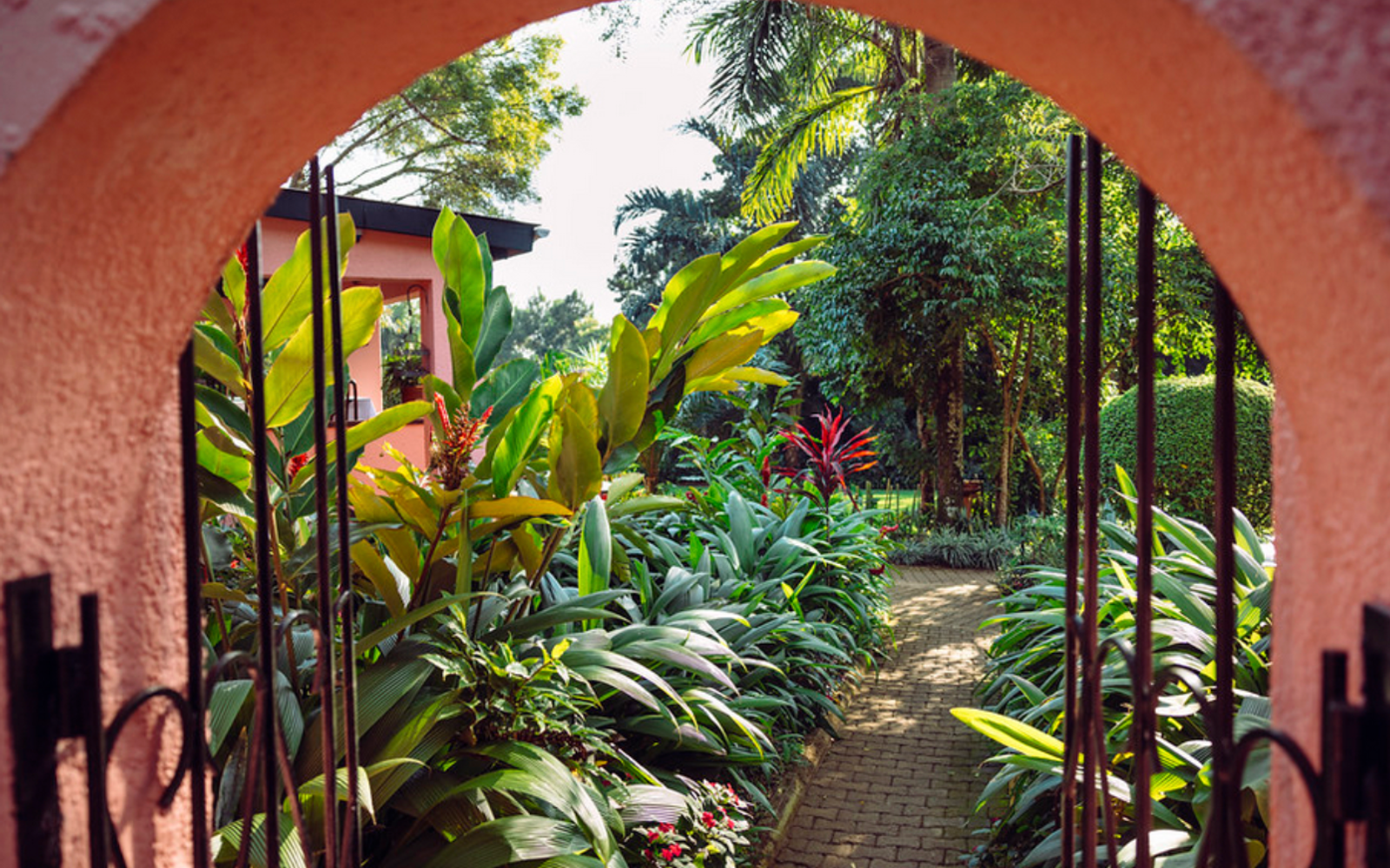 Archway into lush garden of Boma Hotel Entebbe