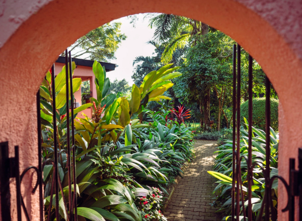 Archway into lush garden of Boma Hotel Entebbe