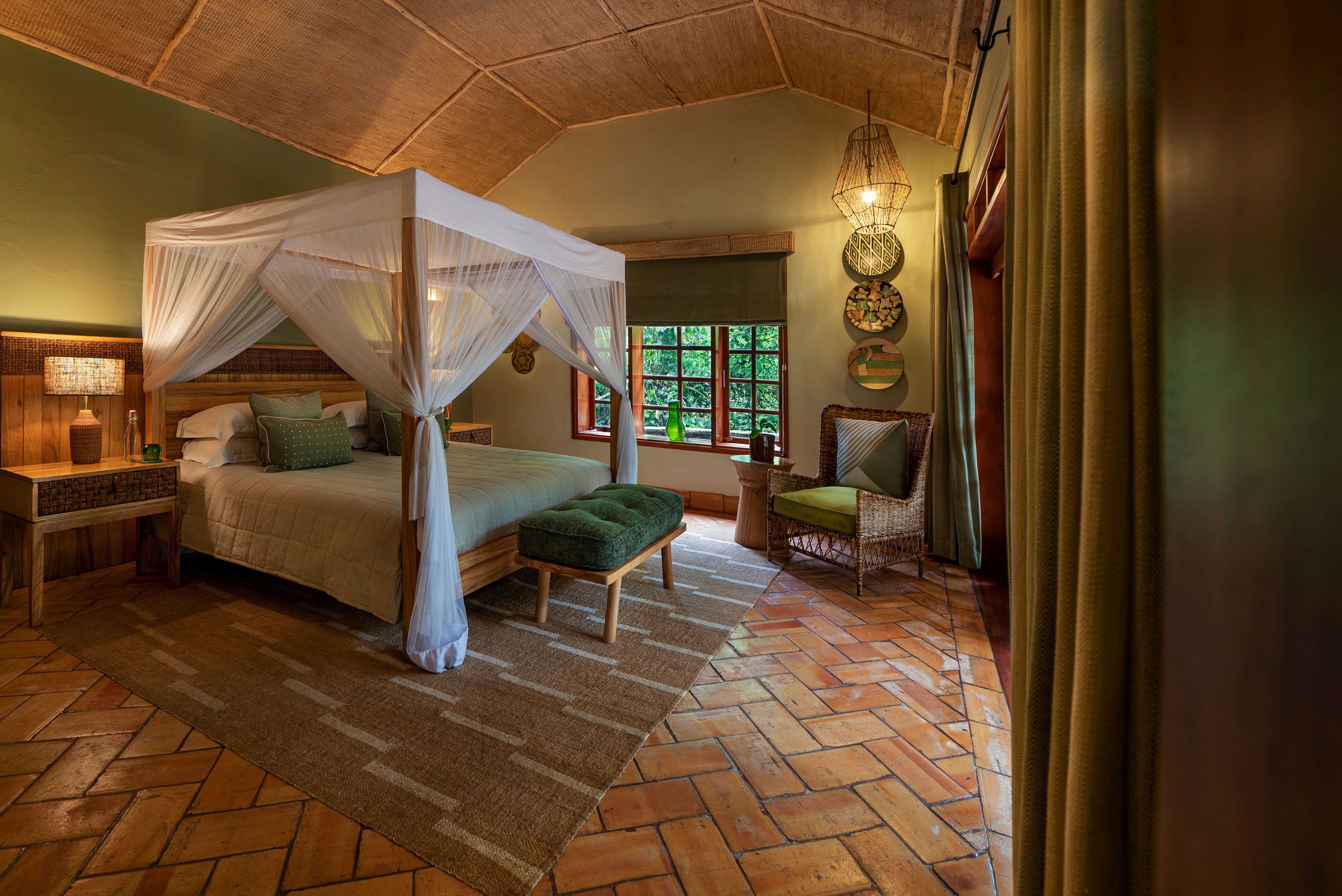 Large four poster bed with mosquito net in honeymoon cottage