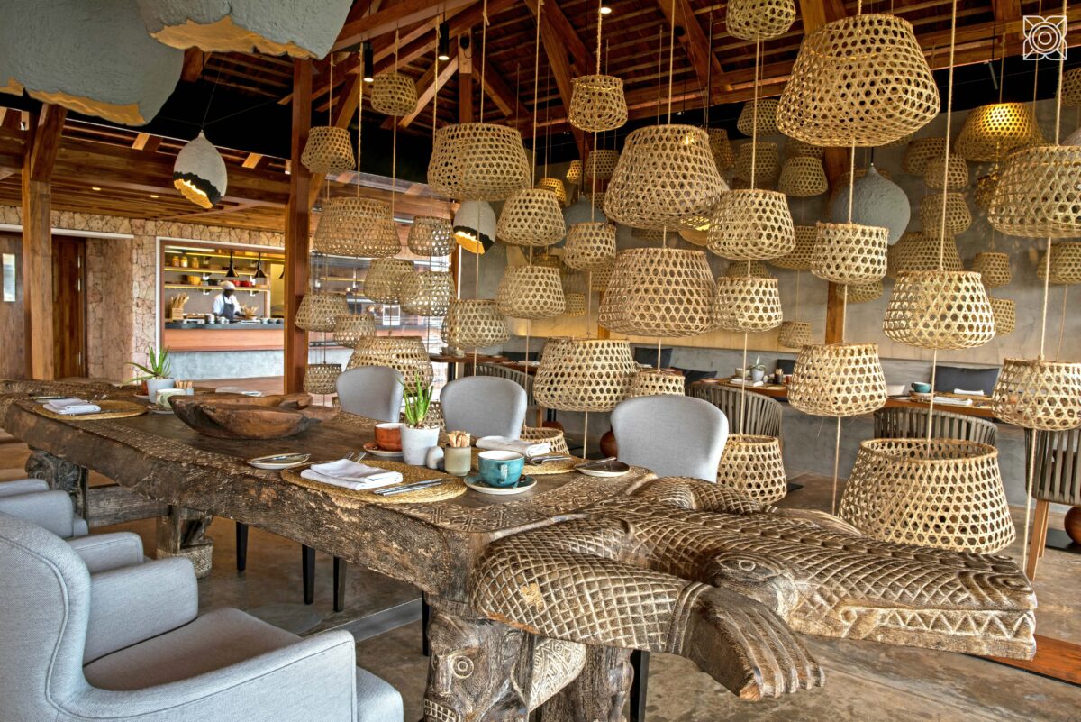 Zuri restaurant with woven lampshade and intricate carved wooden tables