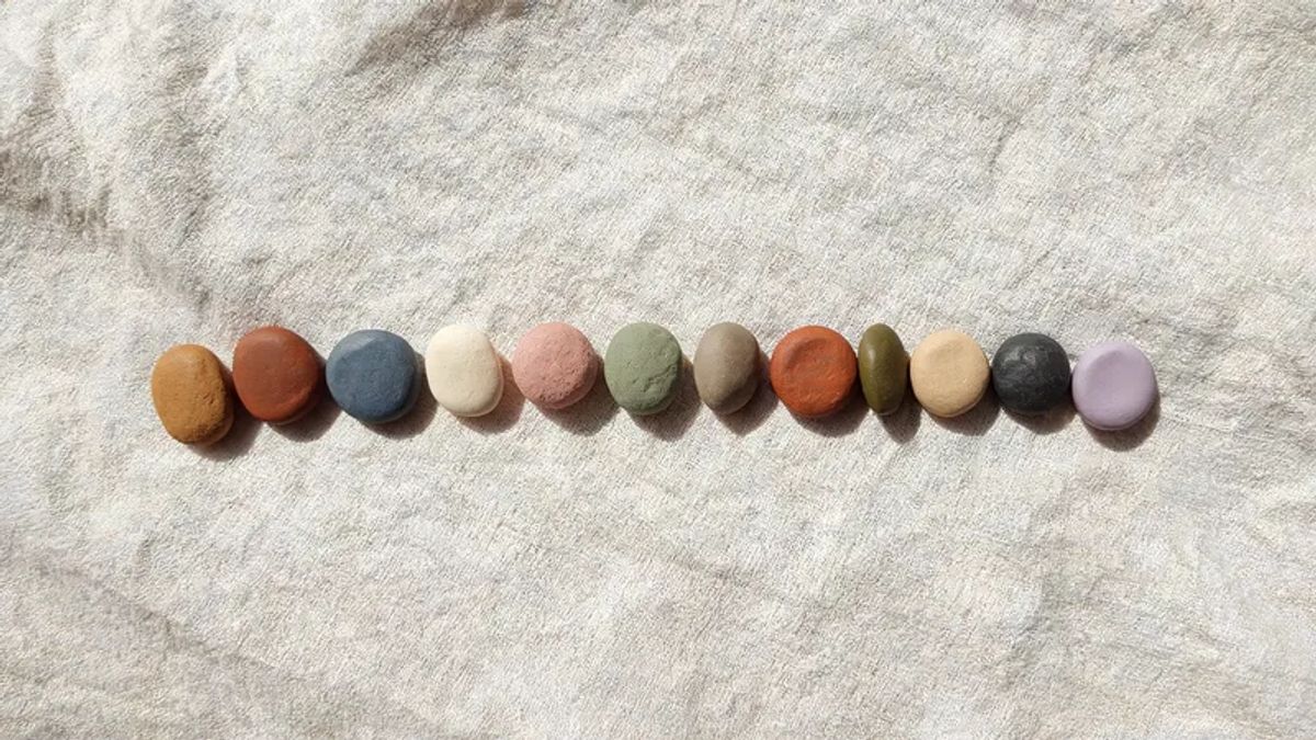 Twelve distinct clay tokens arranged on linen, representing the 12 Character.AI alternatives compared in this article