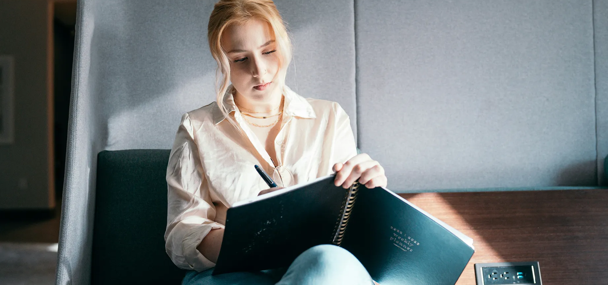 Woman reading in an armchair, with the Cashbee logo