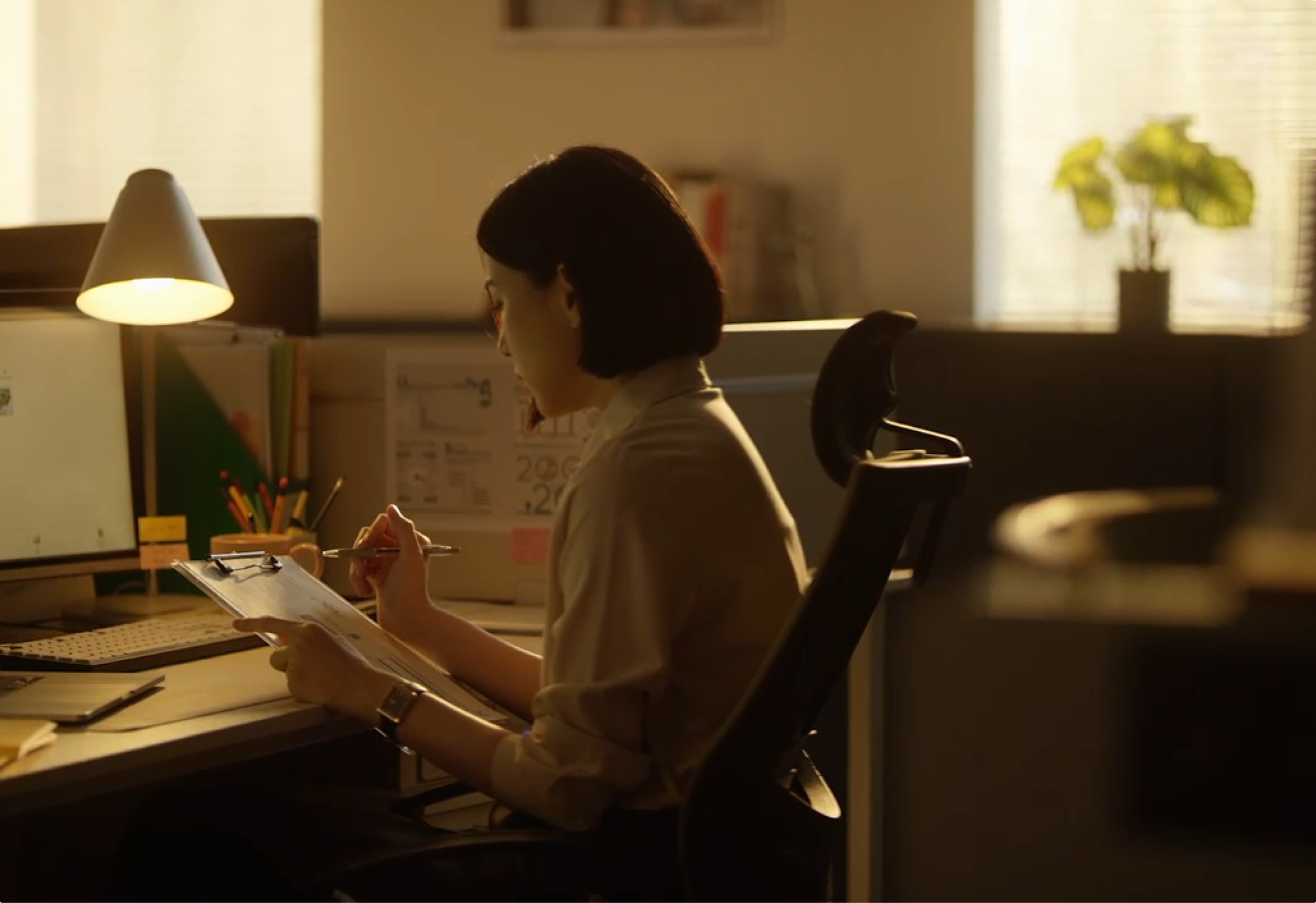 Woman working at a desk by lamplight