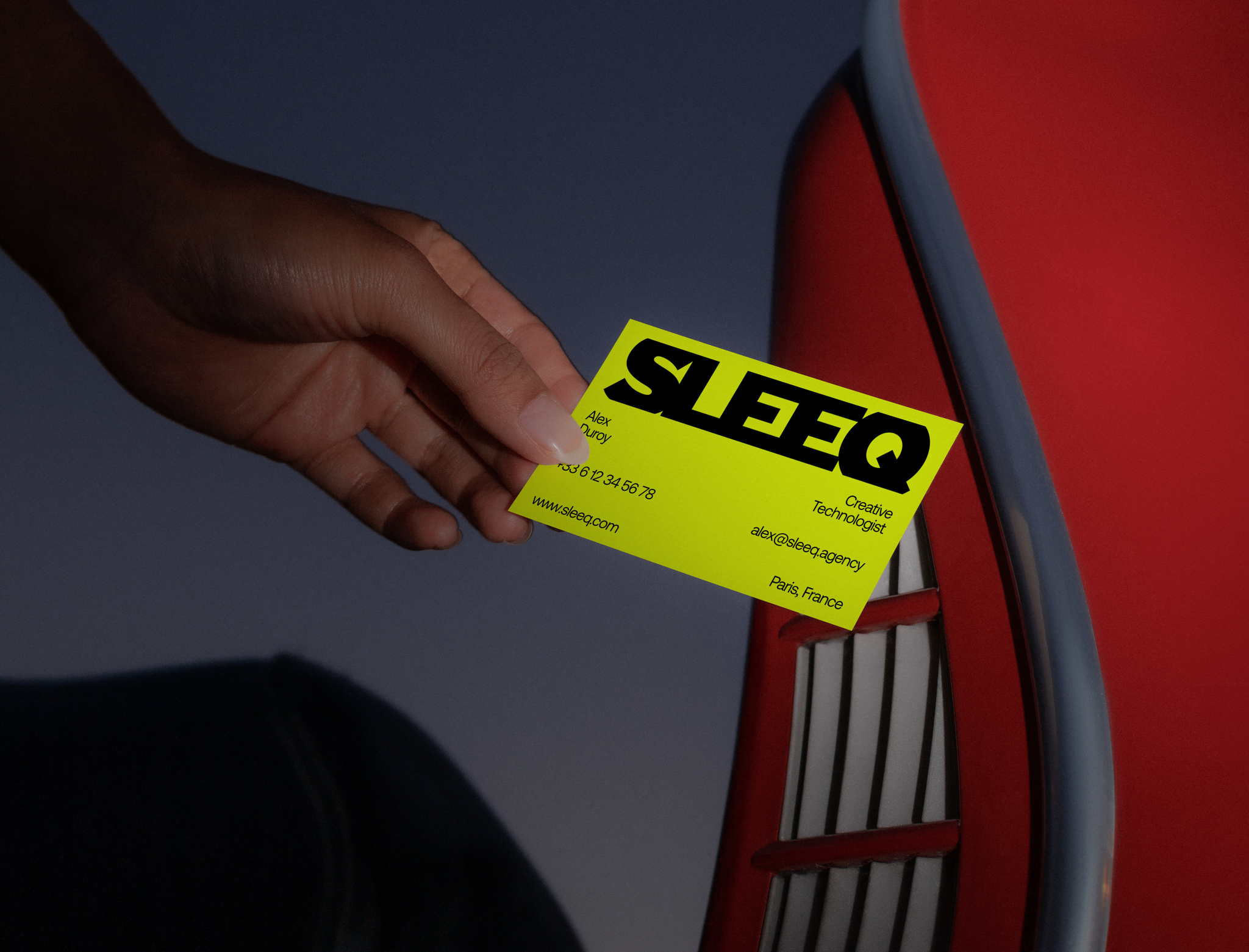 A hand holding a Sleeq business card